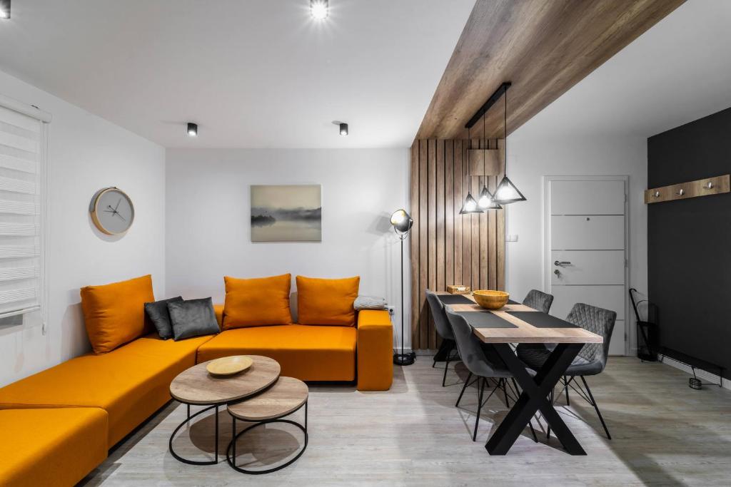 ein Wohnzimmer mit einem gelben Sofa und einem Tisch in der Unterkunft Vila Cander in Kladovo