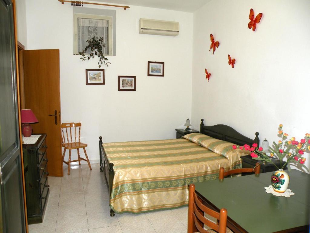 a bedroom with a bed and a table at Appartamenti Holiday Housing Lipari Centro in Lipari