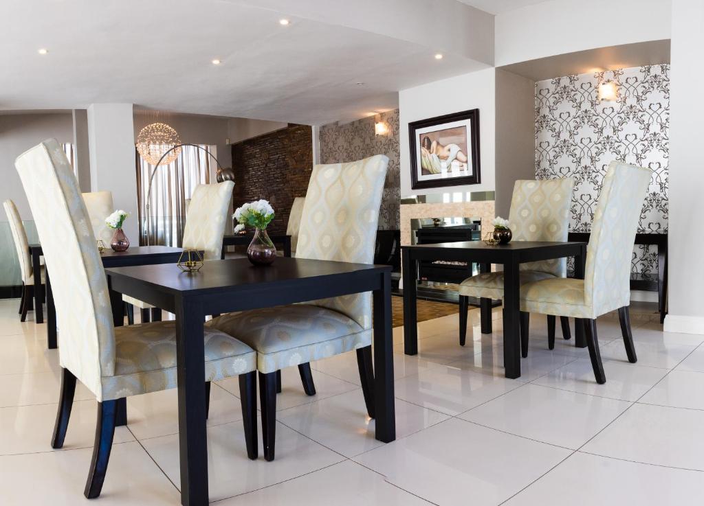 a dining room with a black table and chairs at The Houghton Villa in Johannesburg
