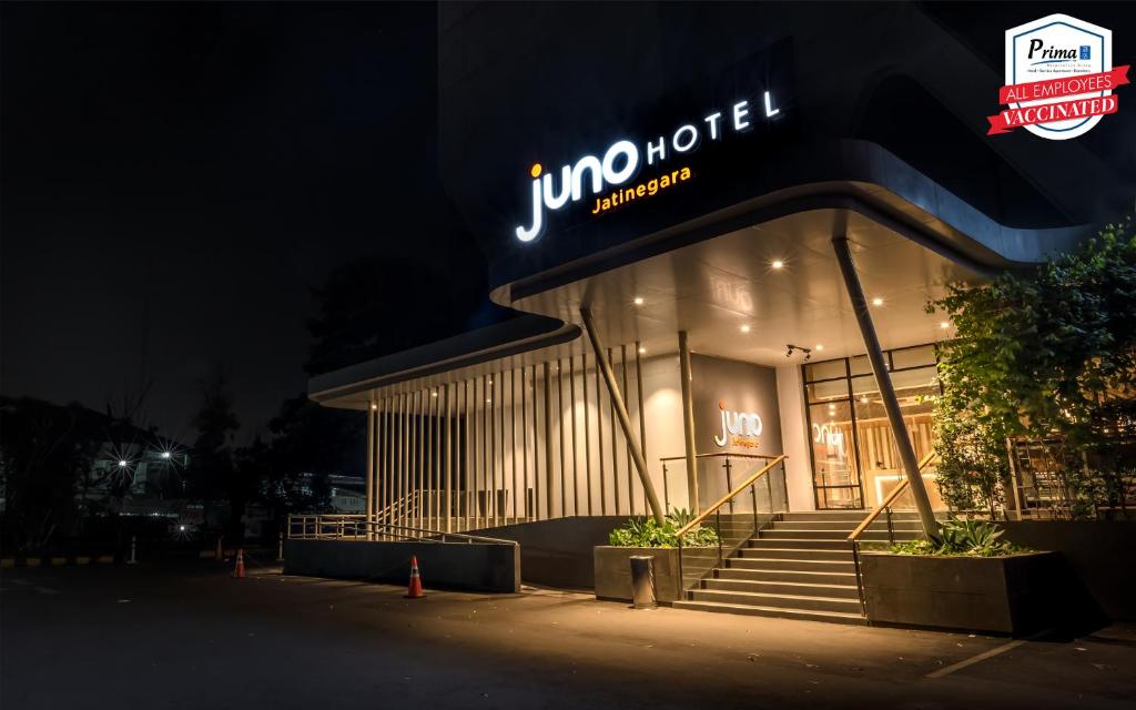 a jumeirah building with a neon sign on it at Juno Jatinegara Jakarta in Jakarta