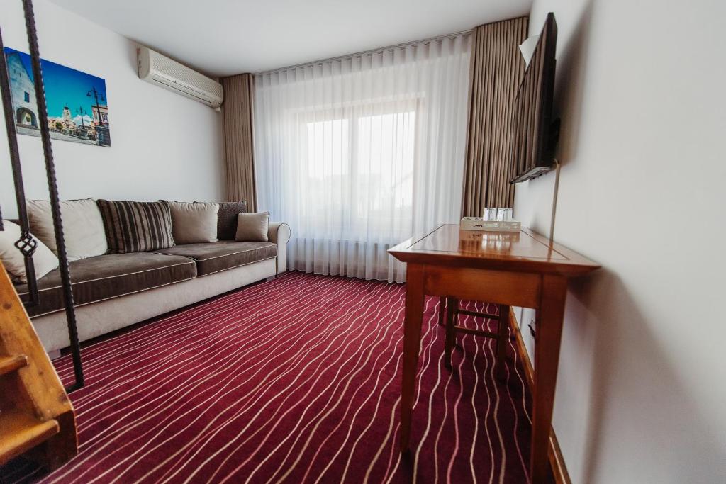 a living room with a couch and a table at Boutique Damiani in Sibiu