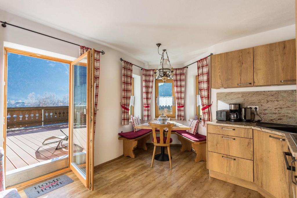 een keuken met een tafel en een balkon bij Ferienwohnung Granat in Mittenwald