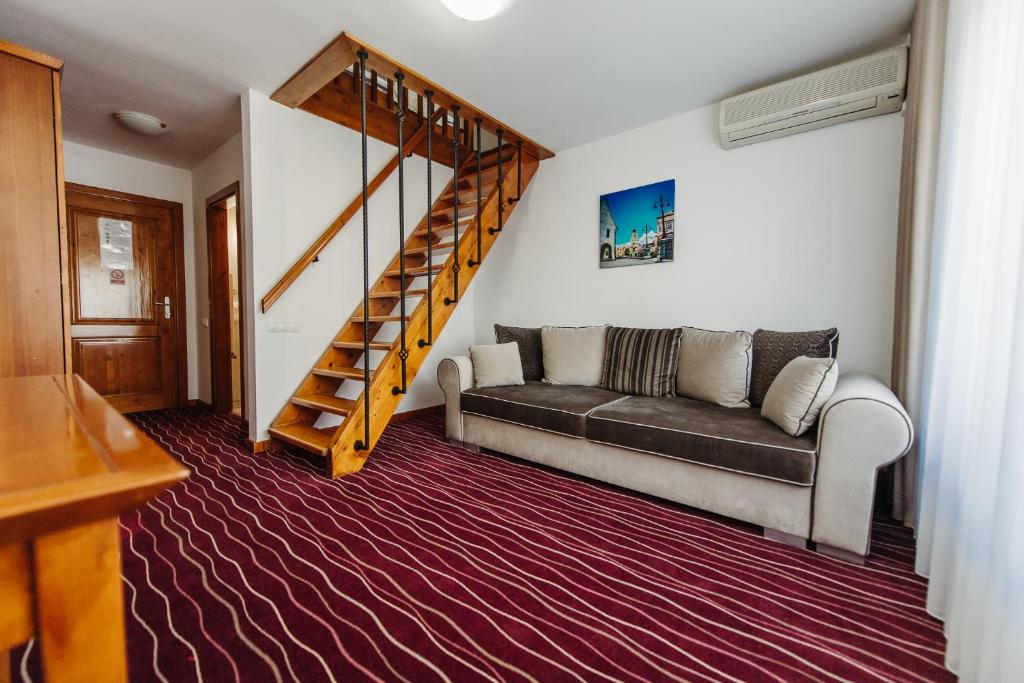 a living room with a couch and a staircase at Boutique Damiani in Sibiu