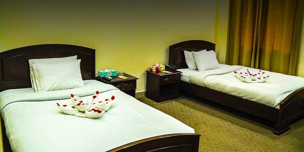 a hotel room with two beds with flowers on them at Eque Heritage Hotel & Resort in Lakshmanpur Bālāpāra