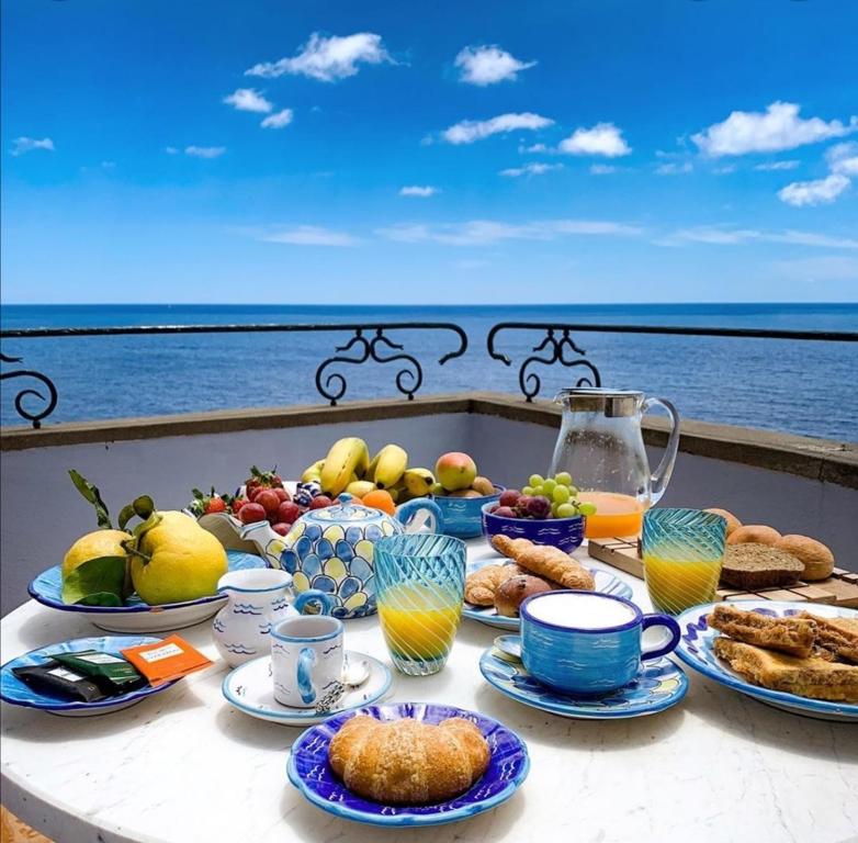 una mesa con comida en ella con el océano en el fondo en Hotel Riposo, en Gatteo a Mare