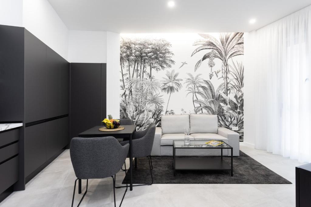 a living room with a white couch and palm trees mural at Home2Book Stunning Apartment Monterosso in Santa Cruz de Tenerife