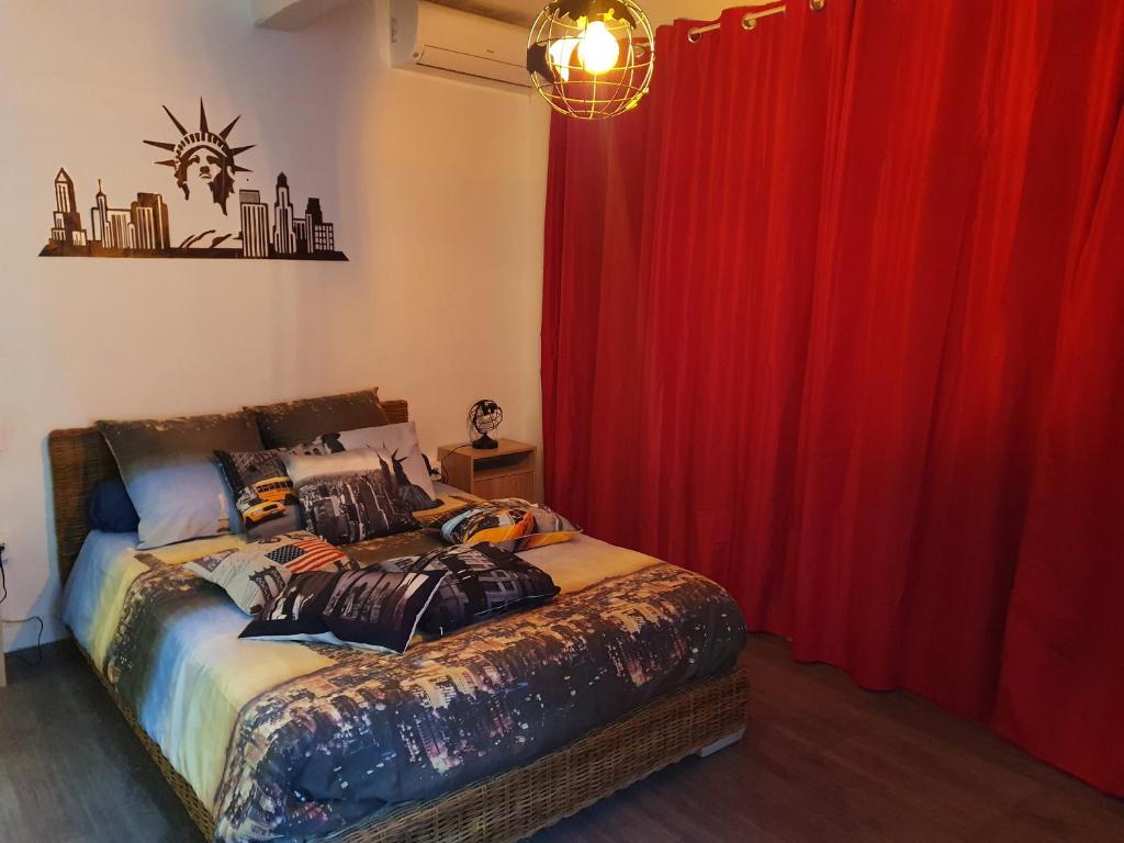 um quarto com uma cama com uma cortina vermelha em Les colombes de l'Occitanie em Ferrals-lès-Corbières