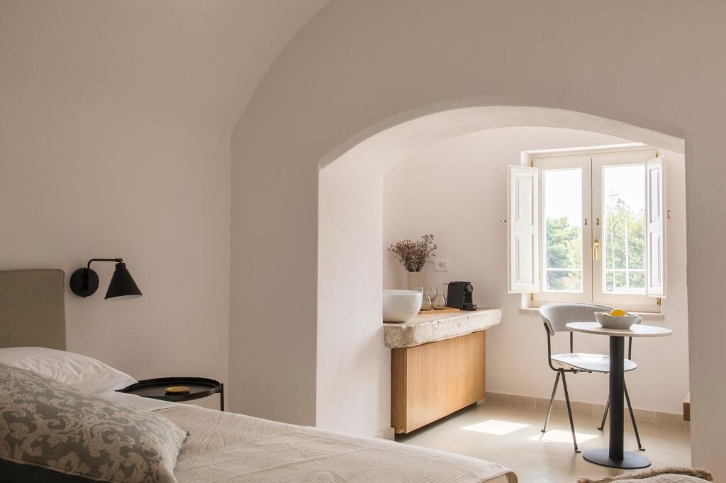 a bedroom with a bed and a table and a window at Palazzo Mulini in Monopoli