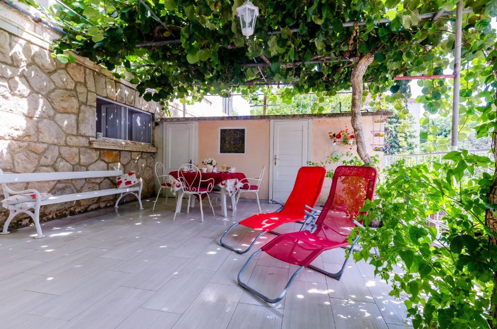 eine Terrasse mit zwei roten Stühlen und einem Tisch in der Unterkunft Apartment Kalea in Dubrovnik