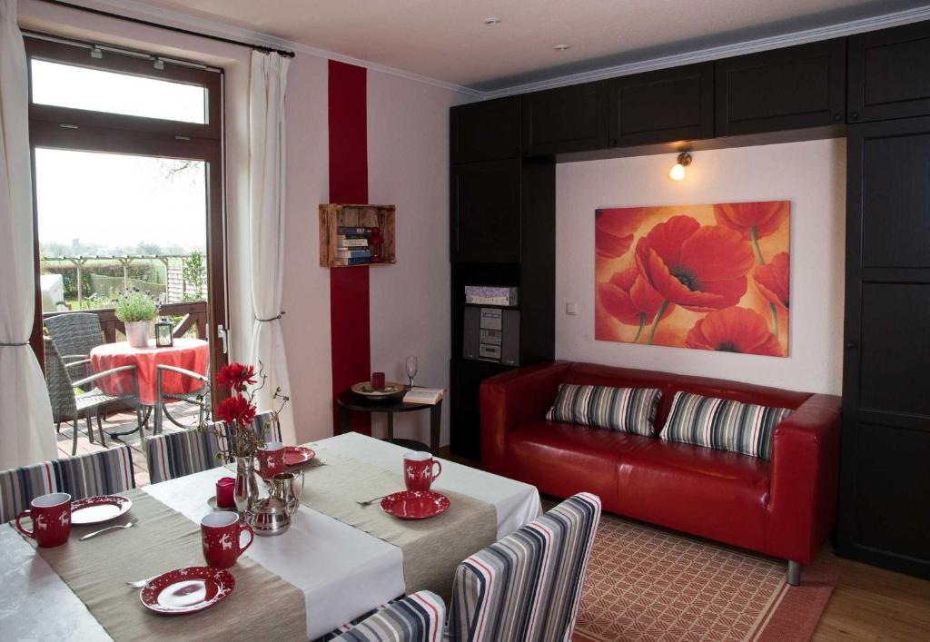 PommerbyにあるFerienwohnung Muehlenblickのテーブルと赤いソファのあるリビングルーム