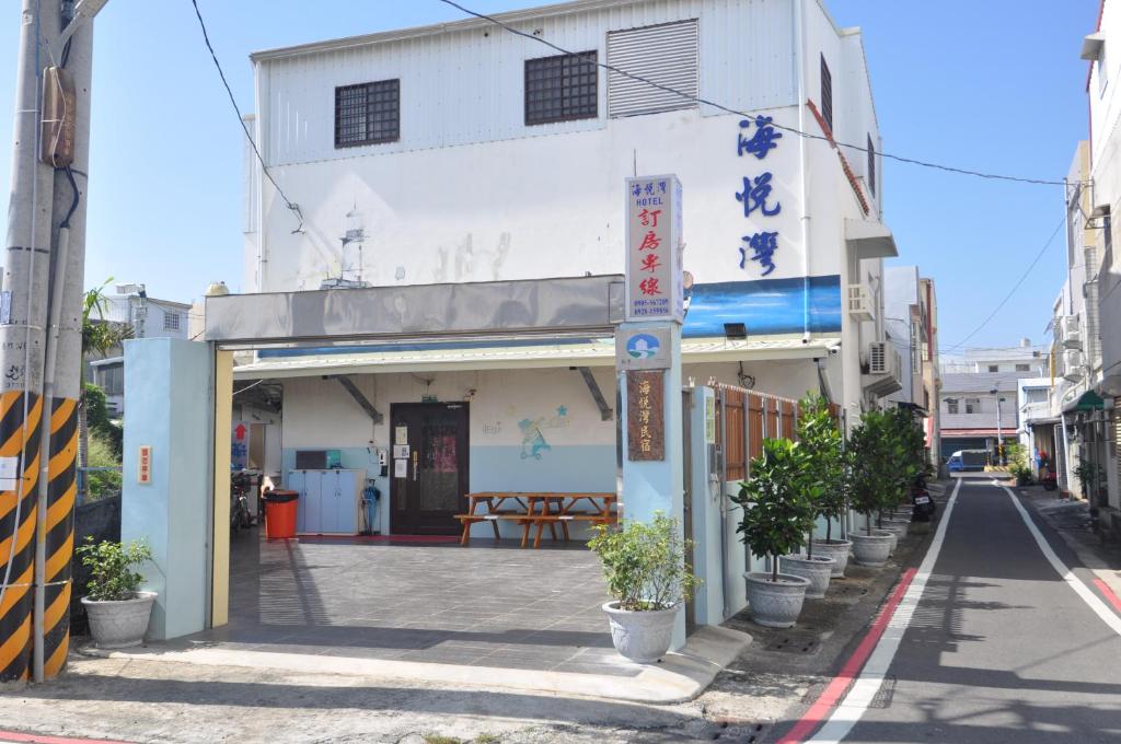 um edifício numa rua com plantas em frente em 海悅灣 em Checheng