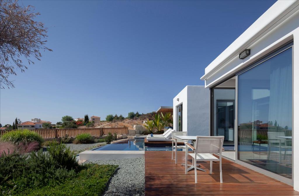 a glass house with a table and chairs on a patio at White Pearl in Paphos