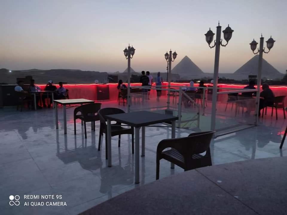 un groupe de tables et de chaises au-dessus d'un bâtiment dans l'établissement Khufu Pyramids Hotel, au Caire