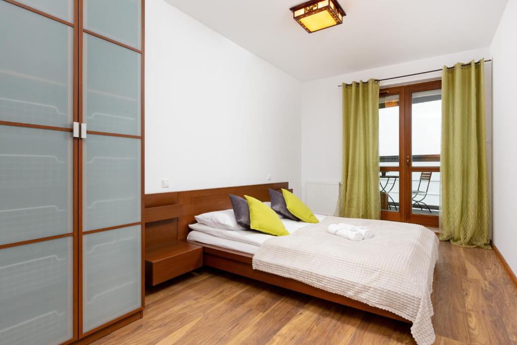 ein Schlafzimmer mit einem Bett mit gelben Kissen in der Unterkunft Metro Wierzbno Apartment by Renters in Warschau