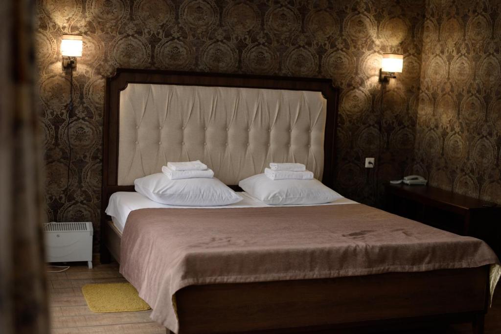 - une chambre avec un grand lit et 2 oreillers dans l'établissement HOTEL PREMIER ROSTOV, à Rostov-sur-le-Don