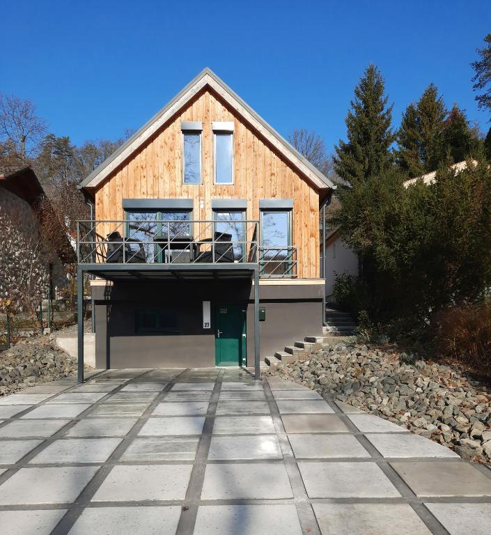 a house with a garage in front of it at Holzhaus Sikonda in Komló