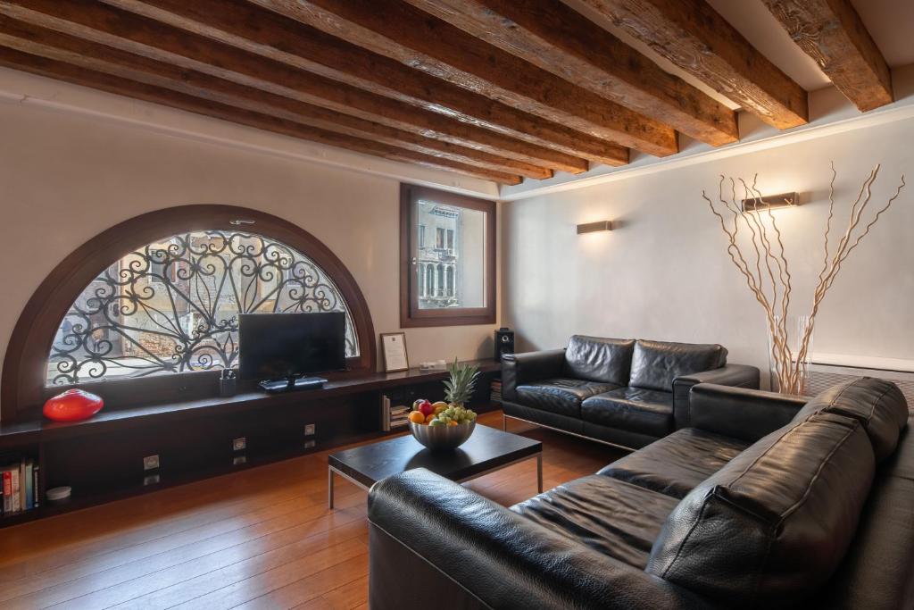 ein Wohnzimmer mit Ledermöbeln und einem großen Fenster in der Unterkunft Ve.N.I.Ce Cera San Moisè in Venedig
