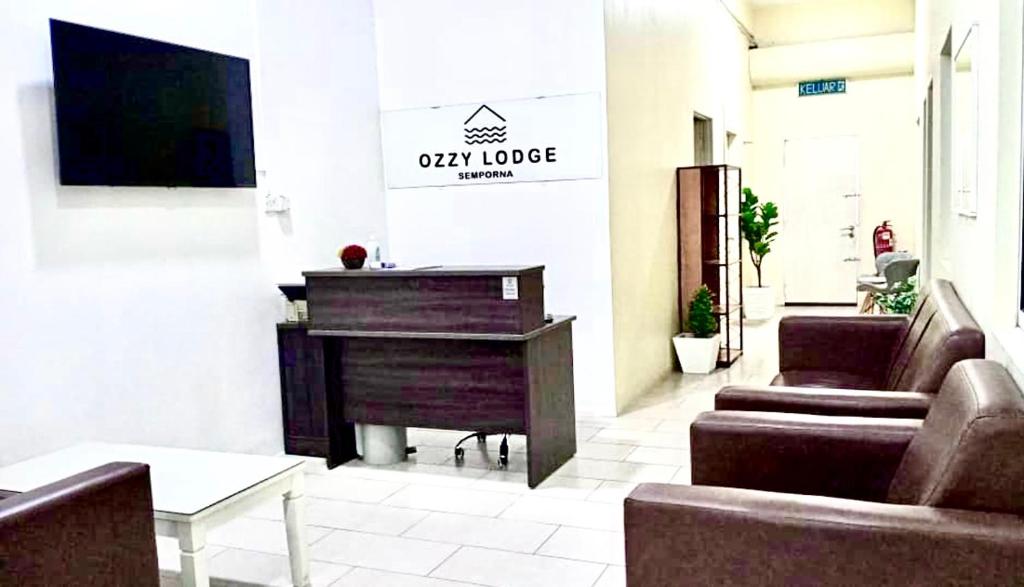 a living room with a piano and a couch at Ozzy Lodge Semporna in Semporna