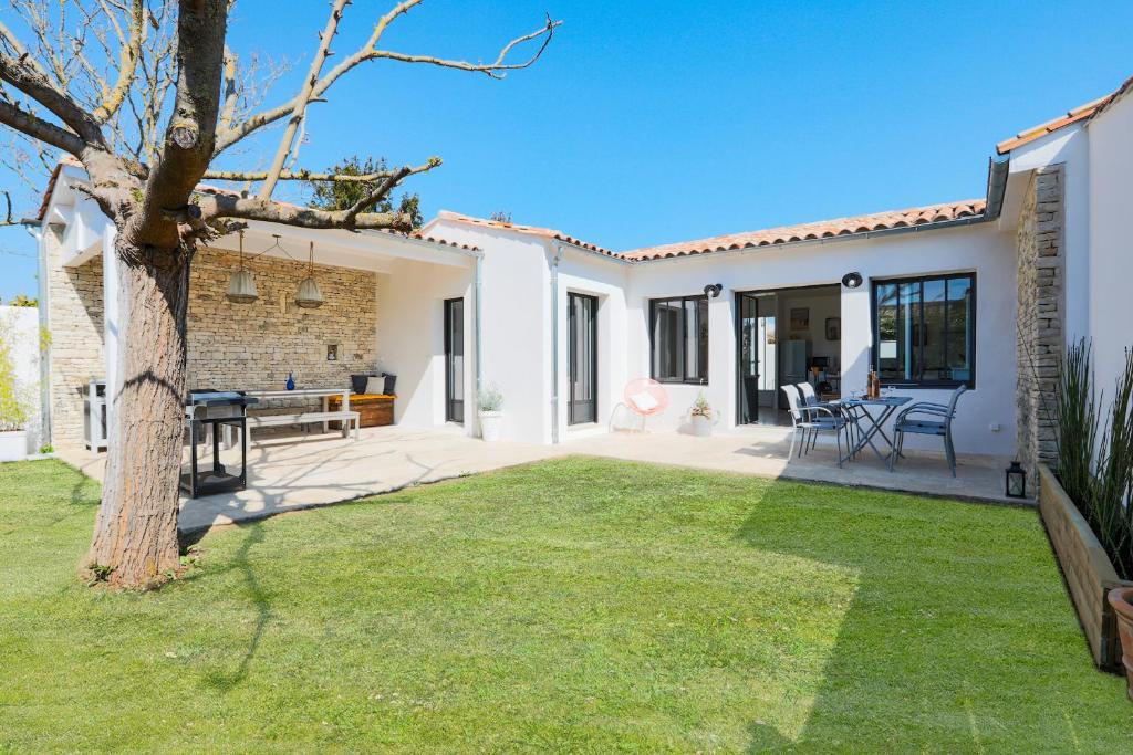 a backyard with a tree and a house at À 550m de la plage, maison pour 4 in Saint-Martin-de-Ré