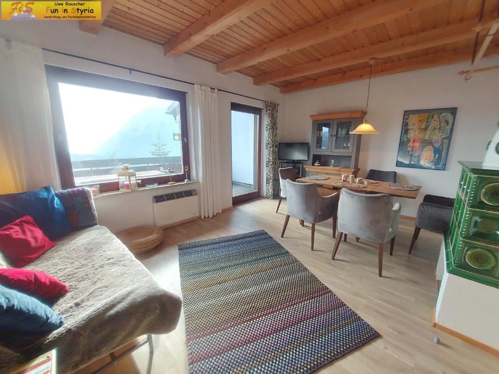 ein Wohnzimmer mit einem Sofa und einem Tisch in der Unterkunft Ferienwohnung Montania by FiS - Fun in Styria in Tauplitz