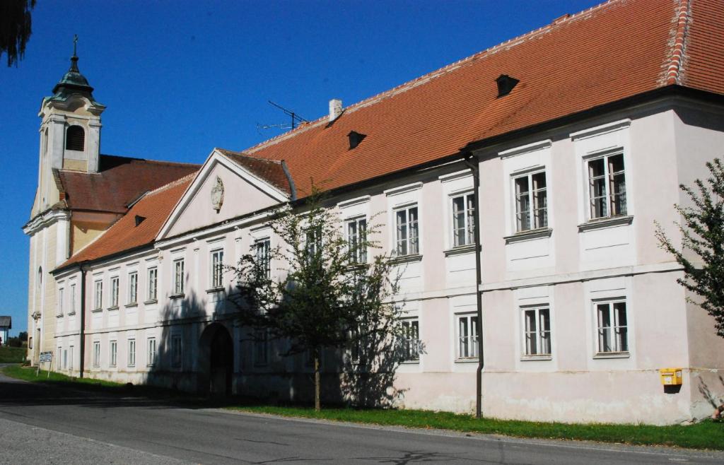 a white building with a red roof and a tower at Pfarrschlössl Sallapulka in Purgstall