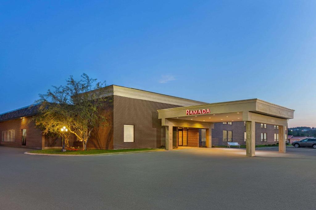 a building with a parking lot in front of it at Ramada by Wyndham Fredericton in Fredericton