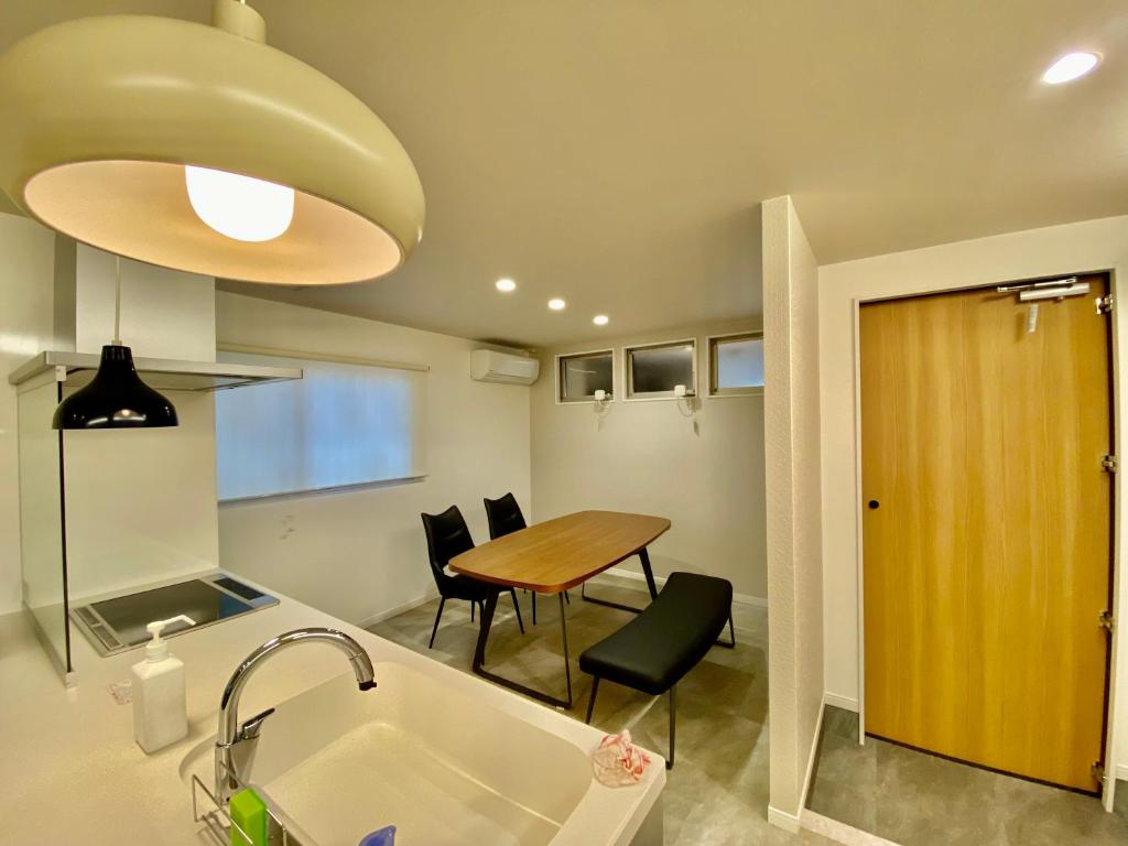 a kitchen and dining room with a table and a sink at Villa Monica in Nagoya