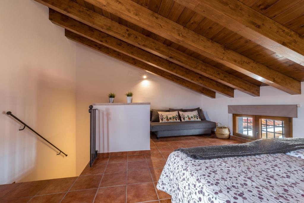 NogueruelasにあるEl Rincón de Braulietaのベッドルーム(ベッド1台、ソファ付)