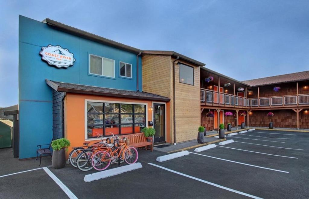 a hotel with bikes parked in a parking lot at Coast River Inn by OYO Seaside in Seaside