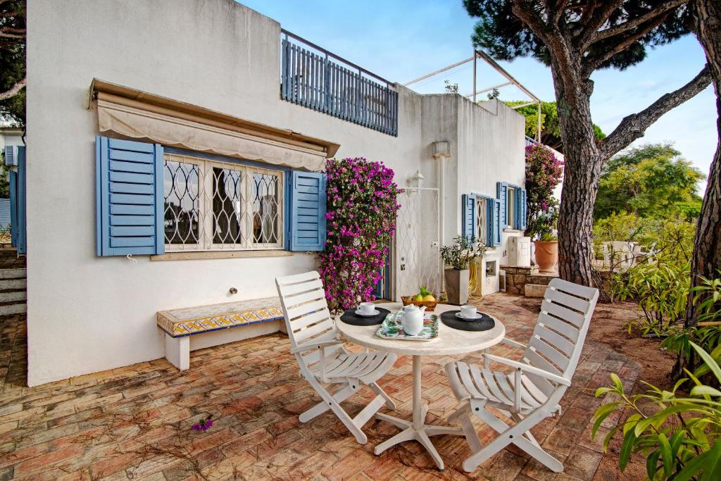 a patio with a table and chairs in front of a house at Villa Apple in Vale do Lobo