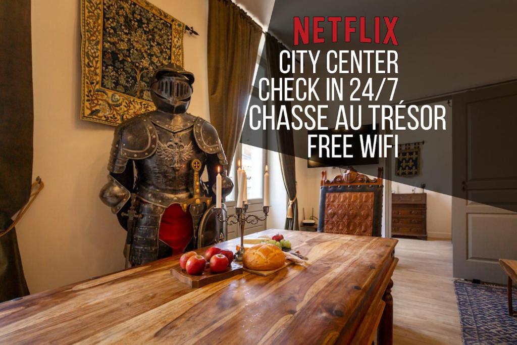 a statue in a room with a table with fruit at Le Secret de la Taverne - Netflix/Wifi - Chasse Aux Trésor à l'intérieur in Carcassonne