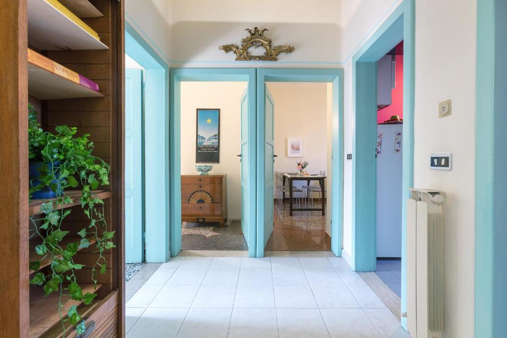 a hallway with blue doors and a table at Saffi Huge Apartment a pochi passi dall'Ospedale in Bologna