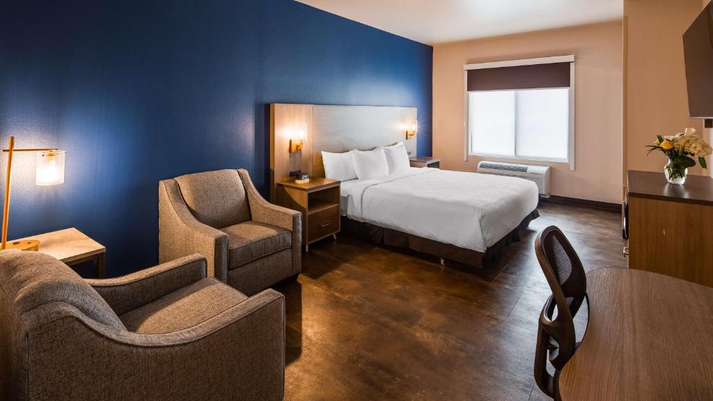 a hotel room with a bed and two chairs at The Forge Hotel BW Signature Collection in Anaconda