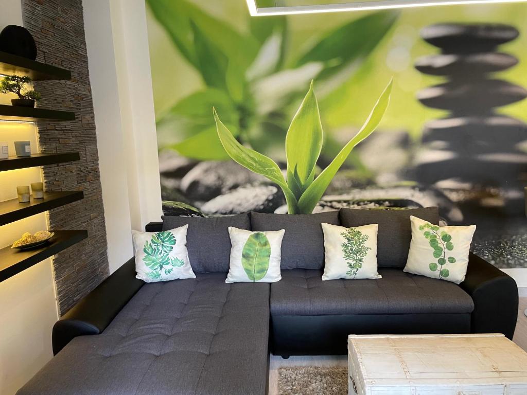 un sofá negro con almohadas en la sala de estar en Zen Apartman, en Eger