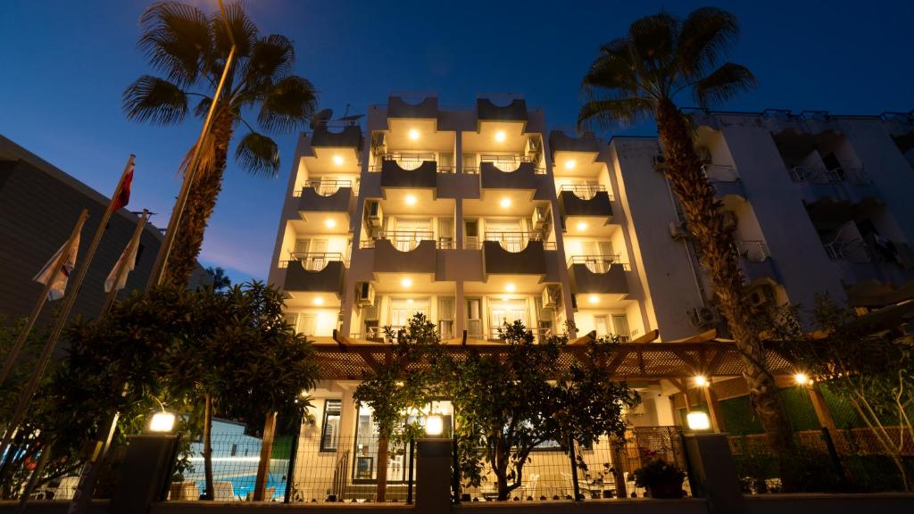 un grand bâtiment avec des lumières allumées la nuit dans l'établissement OPERA Hotel Antalya, à Antalya