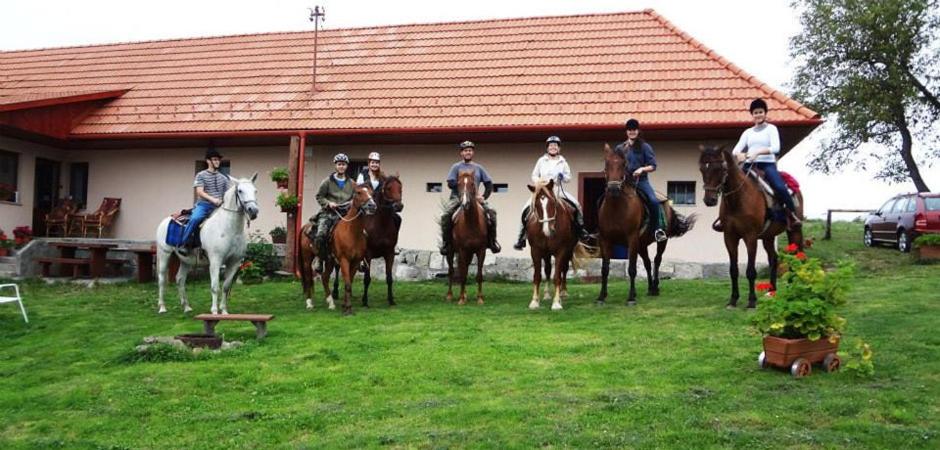 a group of people on horses in front of a house at Ranč pod Žobrákom in Čekovce