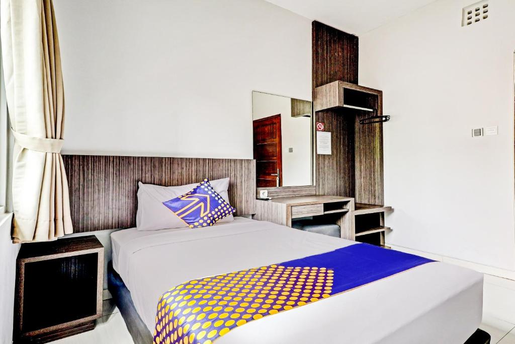 a bedroom with a bed and a television at OYO 90777 D’river Guest House in Bandung