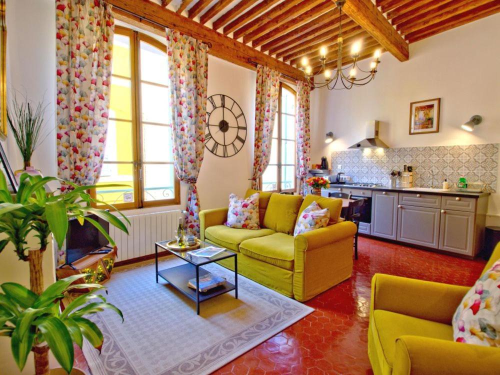 un salon avec des canapés jaunes et une cuisine dans l'établissement Cent Cinq - unique apartments in the heart of Apt, à Apt