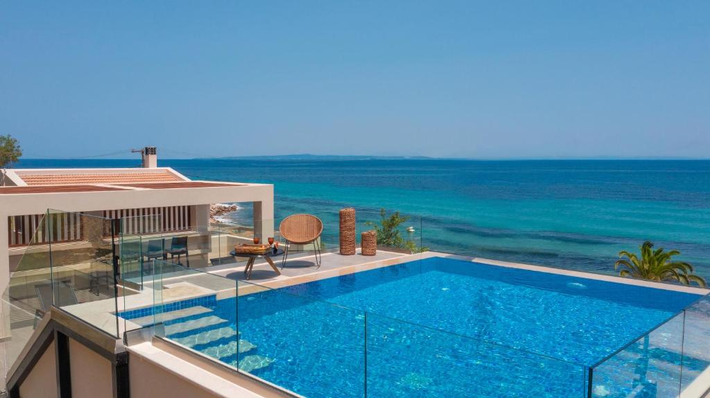 a swimming pool on top of a building with the ocean at Nerea SeaFront Villa, a Pristine Retreat, By ThinkVilla in Akrotiri