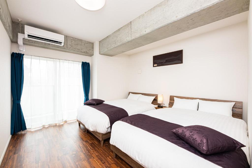 1 dormitorio con 2 camas y ventana en STAYTUS - Vacation STAY 62201v en Kagoshima