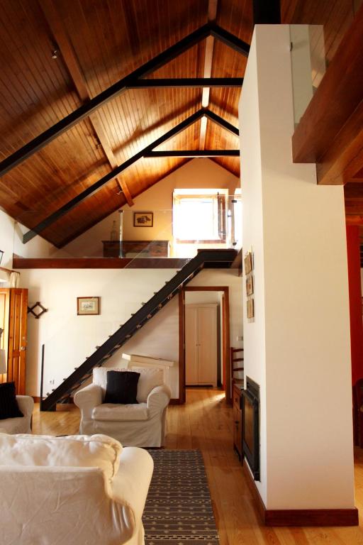 uma sala de estar com mobiliário branco e uma escadaria em Quinta Dos Anjos em Santarém