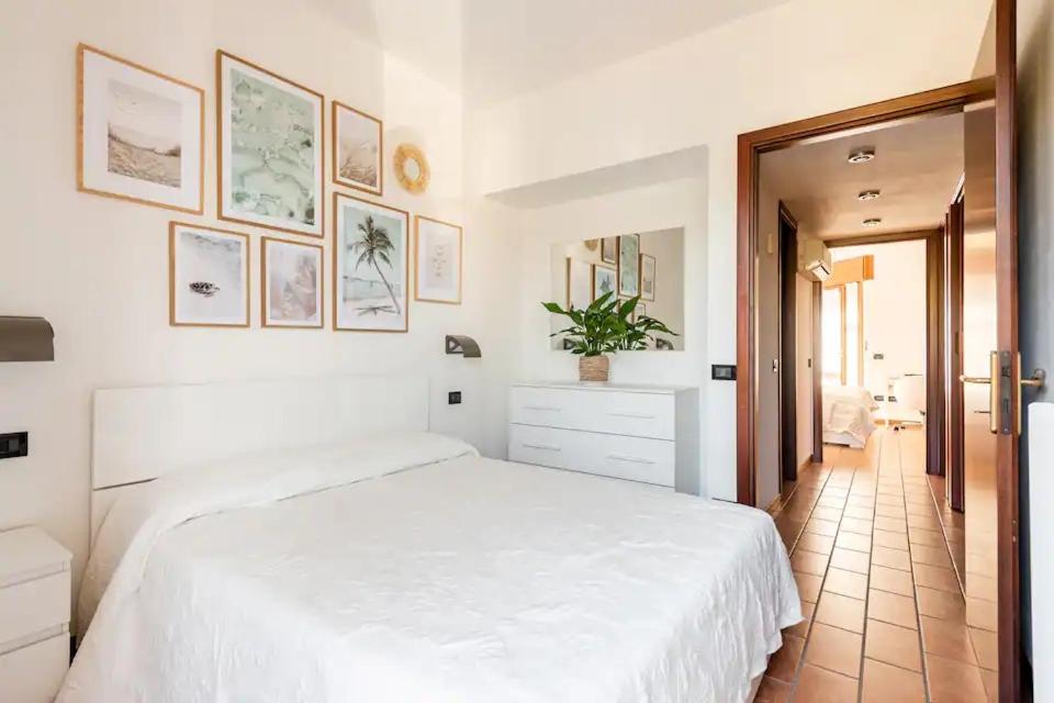 Dormitorio blanco con cama blanca y pasillo en Spacious Villa - private garden near the Sea/Beach, en Porto Santa Margherita