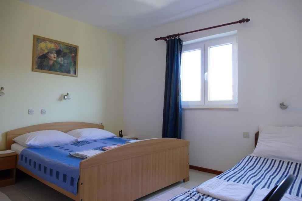 ein Schlafzimmer mit zwei Betten und einem Fenster in der Unterkunft Apartment Barbat 22 in Barbat na Rabu
