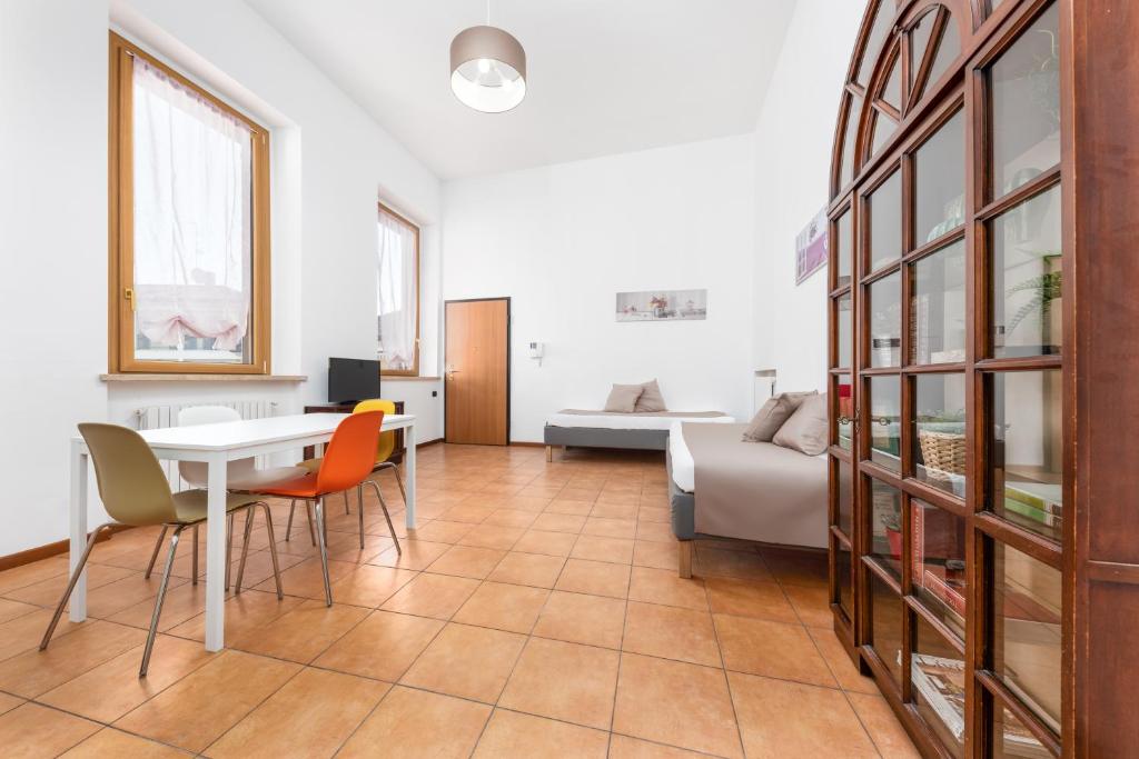 ein Wohnzimmer mit einem Tisch, Stühlen und einem Bett in der Unterkunft Casa da Suite Rho in Rho