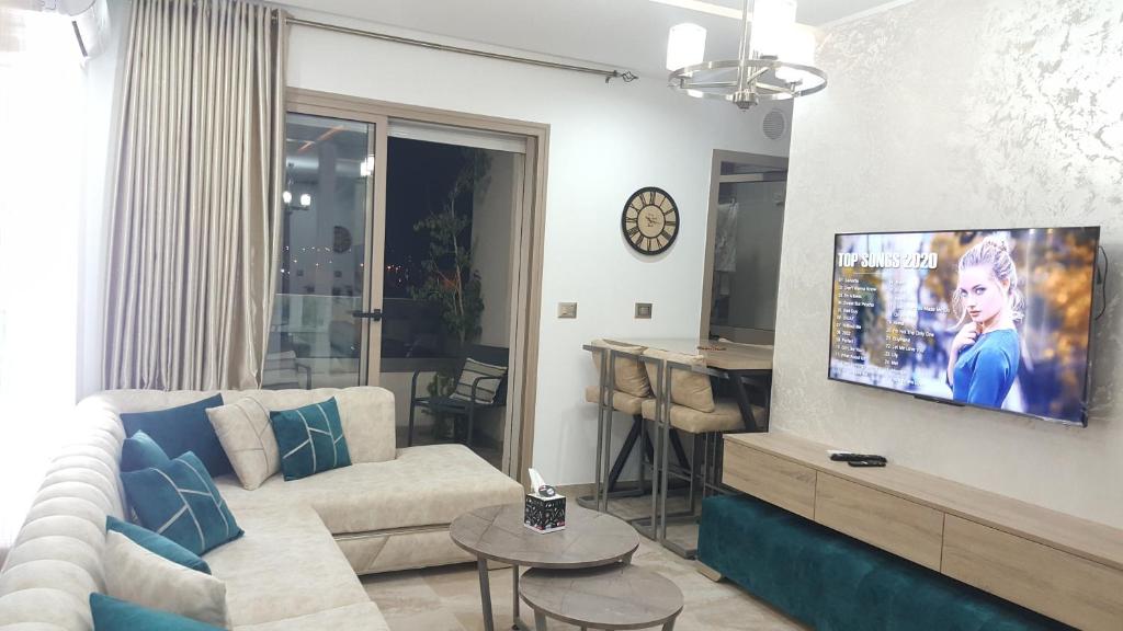 sala de estar con sofá y TV en la pared en Design & luxury apartment with sea view in Mrezga Hammamet, en Nabeul