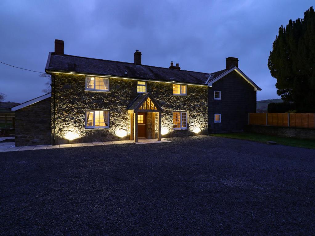 a stone house with lights on the front of it at Bodaioch Cottage in Caersws