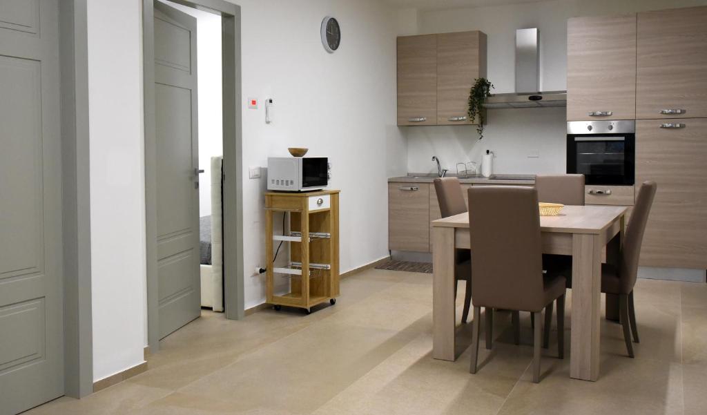 eine Küche und ein Esszimmer mit einem Tisch und Stühlen in der Unterkunft Dea Igea Apartment in Bellaria-Igea Marina