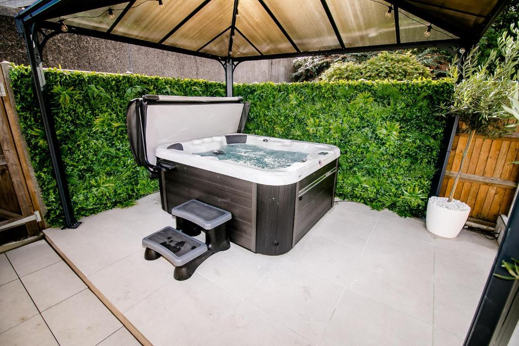 a hot tub in the middle of a patio with an umbrella at Beautiful City-Centre Townhouse with Hot Tub in Norwich