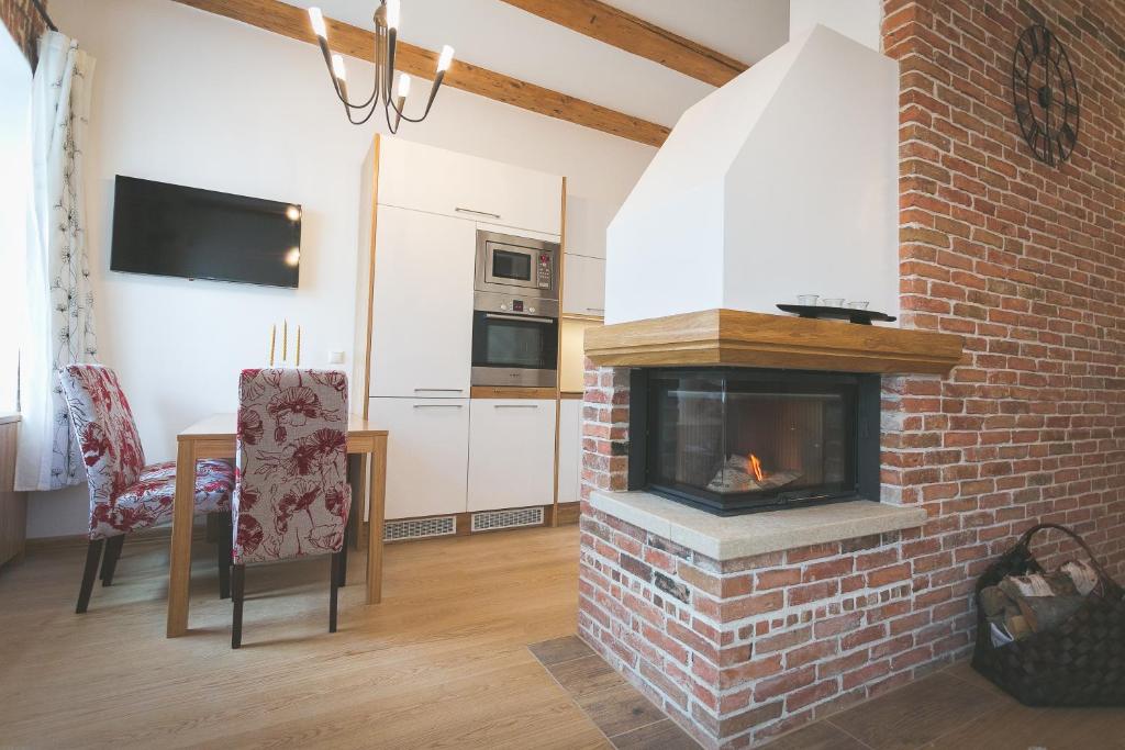a living room with a brick fireplace next to a kitchen at Arina Guest Apartment in Kuressaare