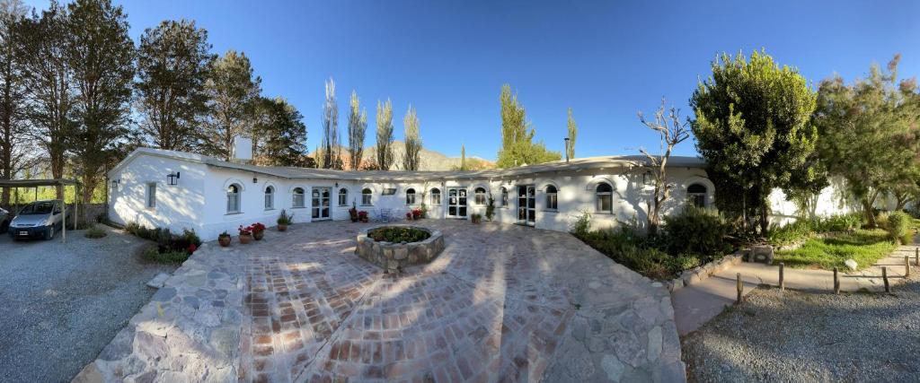 a large white building with a fountain in a yard at Pumahuasi Hotel Boutique in Purmamarca